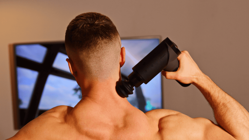 image of a man using a massage gun for workout recovery